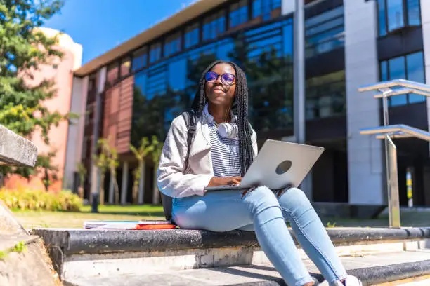 a girl smiling while holding a laptop